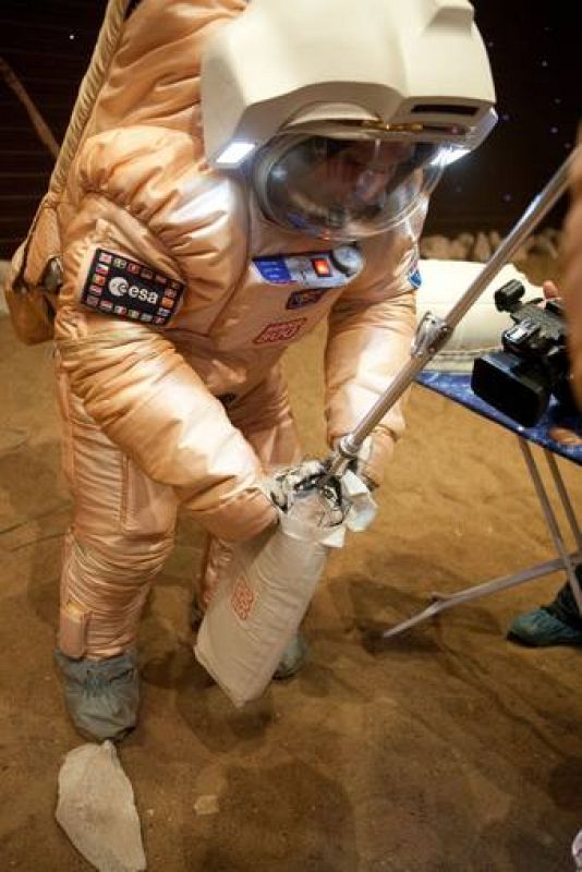 Uno de los astronautas recoge una de las muestras del 'planeta marciano'