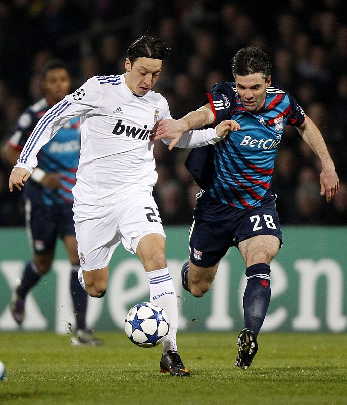 Olympique Lyon's Toulalan challenges Real Madrid's Oezil during their Champions League soccer match in Lyon