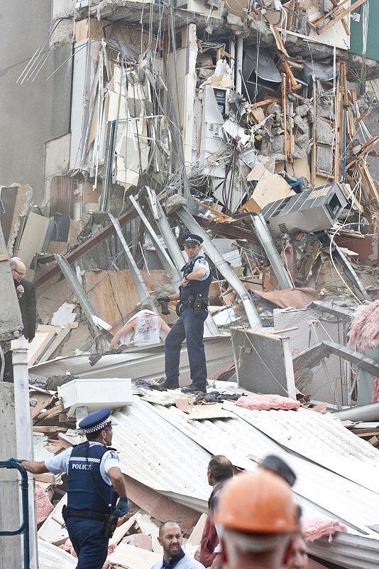 Un policia intenta coordinar las labores de rescate en el edificio de la CTV antes de que se suspendieran por razones de seguridad