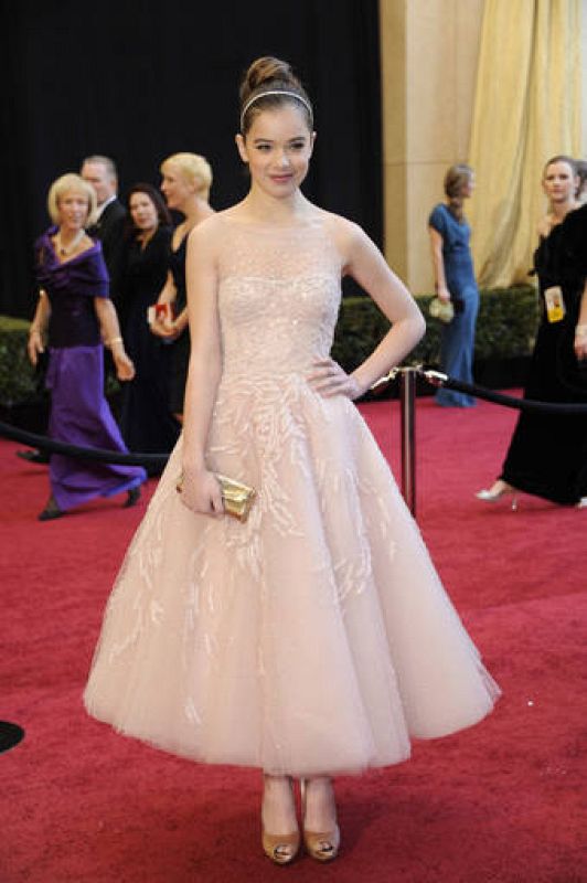  El modelo de la jovencísima Hailee Stenfield es de la casa Marchesa. Un modelo de línea princesa de tul bordado en plata. 