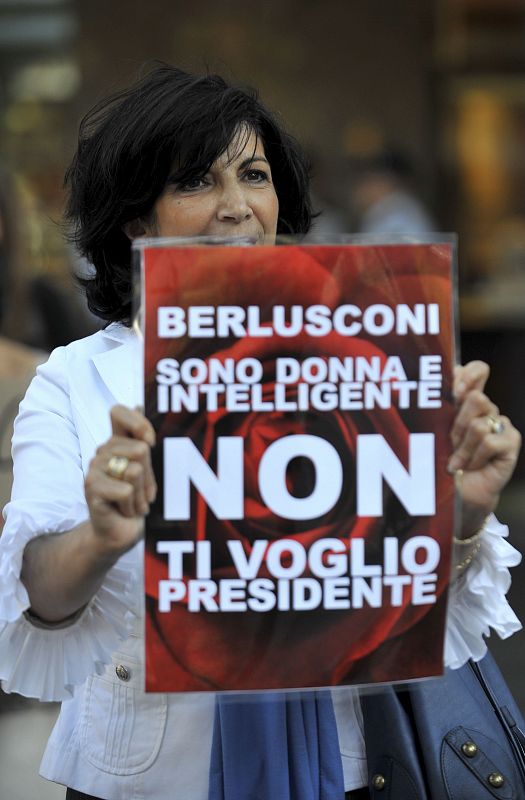 Una mujer muestra un letrero en el que se puede leer "Berlusconi. Soy una mujer e inteligente, no te quiero como presidente" durante una marcha protagonizada por la comunidad italiana en contra del primer ministro italiano, Silvio Berlusconi