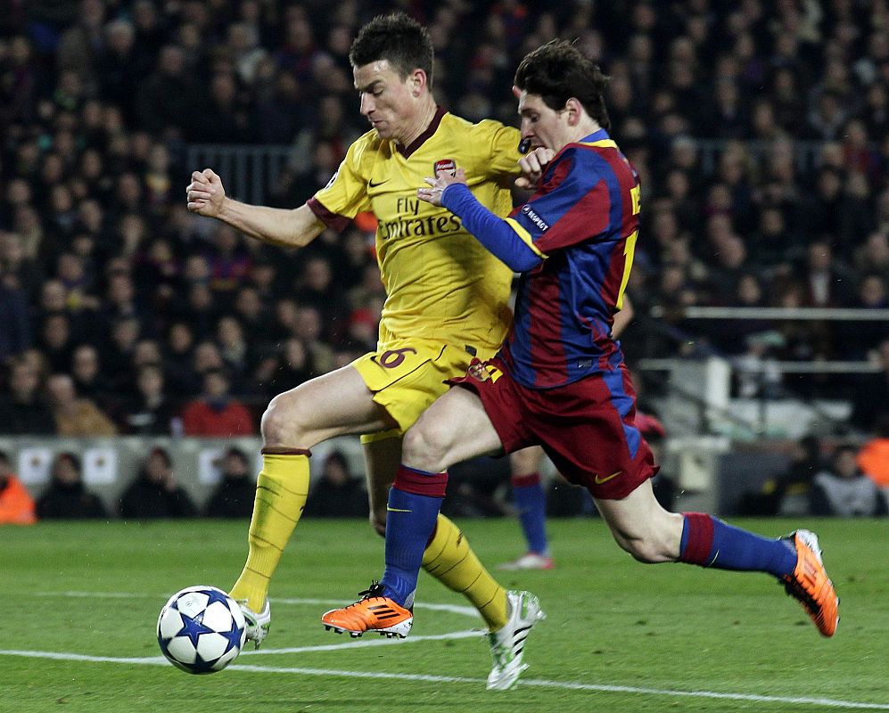 Arsenal's Koscielny is challenged by Barcelona's Messi during their Champions League soccer match in Barcelona