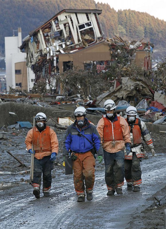 Un grupo de voluntarios pasa junto a una casa destruida de la ciudad de Minamisanriku, en la prefectura de Miyagi