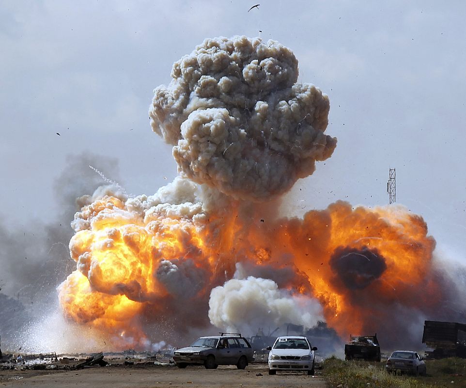 Vehicles belonging to forces loyal to Libyan leader Muammar Gaddafi explode after an air strike by coalition forces, along a road between Benghazi and Ajdabiyah