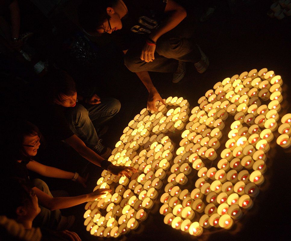 People form the number 60, representing the 60 minutes of Earth Hour, with candles during Earth Hour  in Singapore