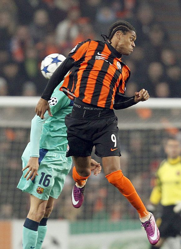 El brasileño Luiz Adriano (delante) del Shakhtar salta por el balón con Sergio Busquets (atrás).