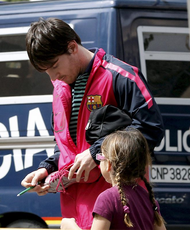 El delantero argentino Leo Messi firma un autógrafo a una joven aficionada a la llegada de los jugadores del FC Barcelona al hotel en el que permanecerán hasta la hora en que se dirigirán al estadio de Mestalla (Valencia)