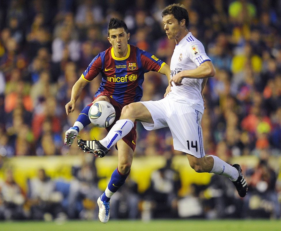 Barcelona's David Villa jumps for the ball against Real Madrid's Alonso during their the King's Cup final soccer match in Valencia