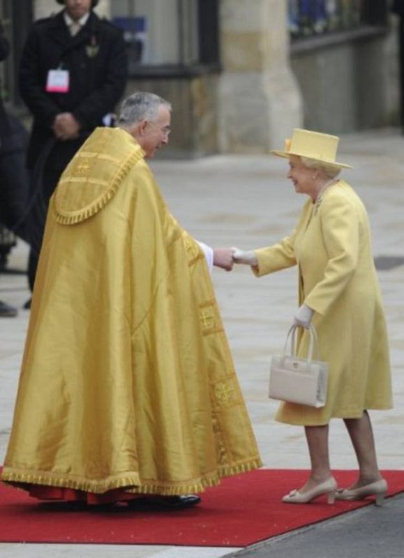 La reina Isabel, con un vestido de color amarillo.