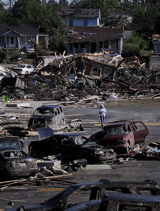 Una mujer camina entre los escombros de una zona devastada por un tornado en Tuscaloosa