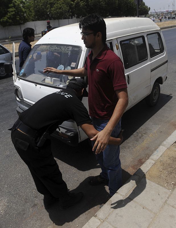 Un policía registra un vehículo a la entrada del consulado estadounidense en Karachi (Pakistán), donde se han reforzado las medidas de seguridad