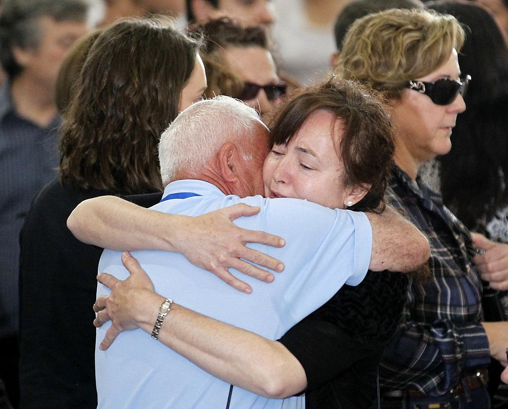 Family members of earthquake victims embrace at a funeral ceremony in Lorca