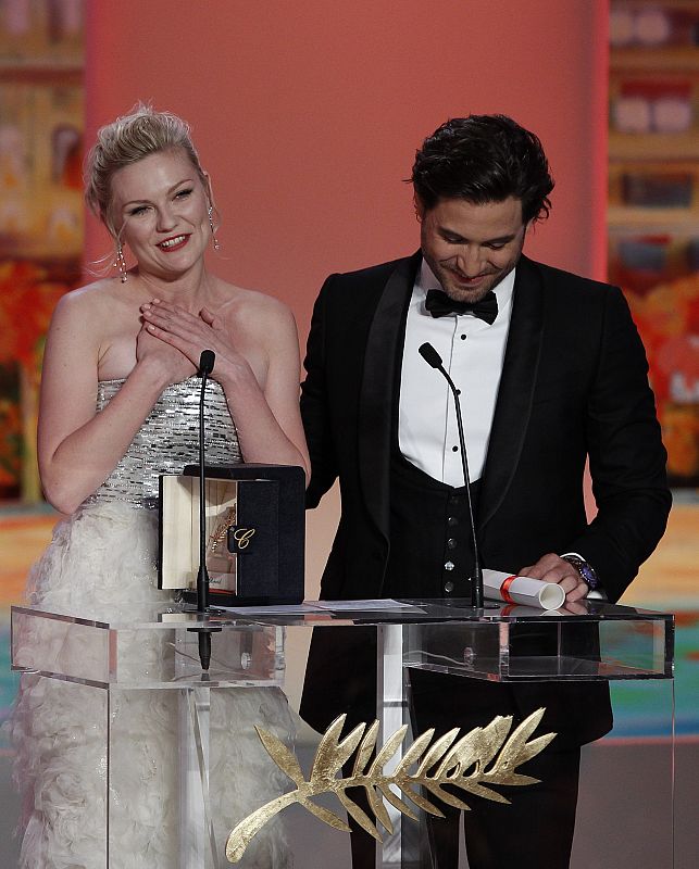 La actriz Kirsten Dunst agradece el premio como mejor actriz en el festival de Cannes por su participación en 'Melancholia'. Junto a ella, el actor Edgar Ramirez, que le ha entregado el galardón.