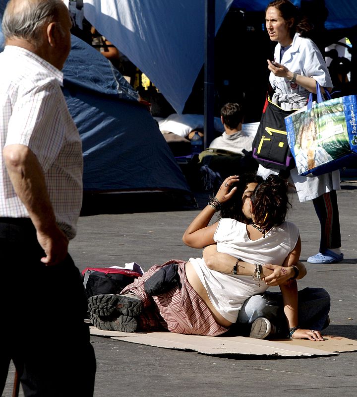 Imagen de una pareja en la Puerta del Sol de Madrid, donde continúa la concentración.