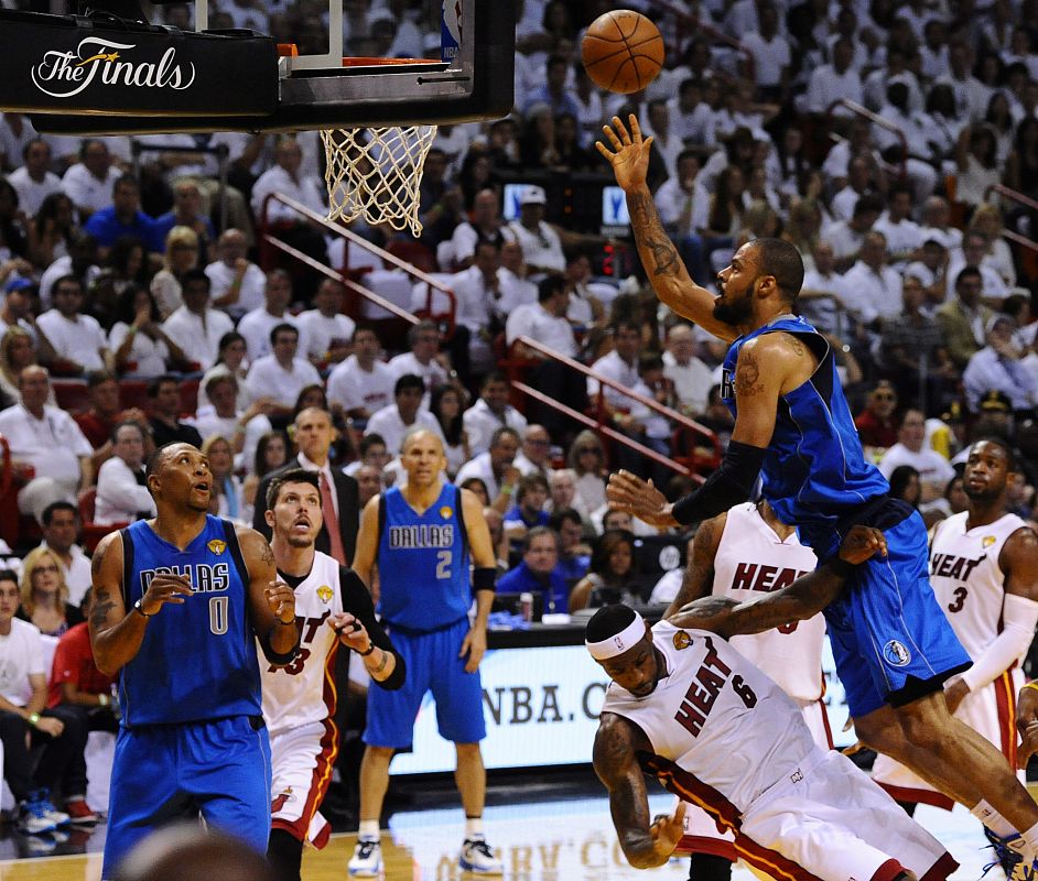 El jugador Tyson Chandler (d) de los Mavericks de Dallas en acción ante la defensa de LeBron James de los Heat de Miami