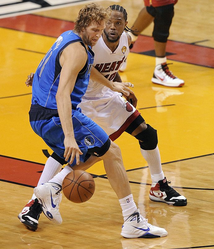 El jugador Dirk Nowitzki de los Mavericks de Dallas lucha por el balón con Udonis Haslem de los Heat de Miami.