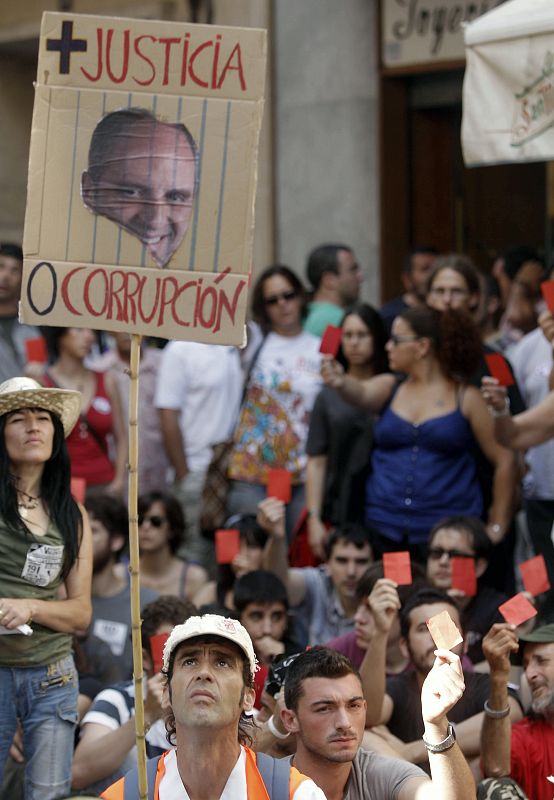 Uno de los manifestantes porta una pancarta con la fotografía del president de la Generalitat, Francisco Camps.
