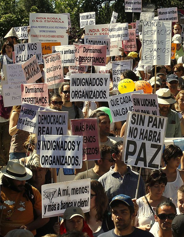 Demonstrators holding banners march towards the Spanish parliament in Madrid