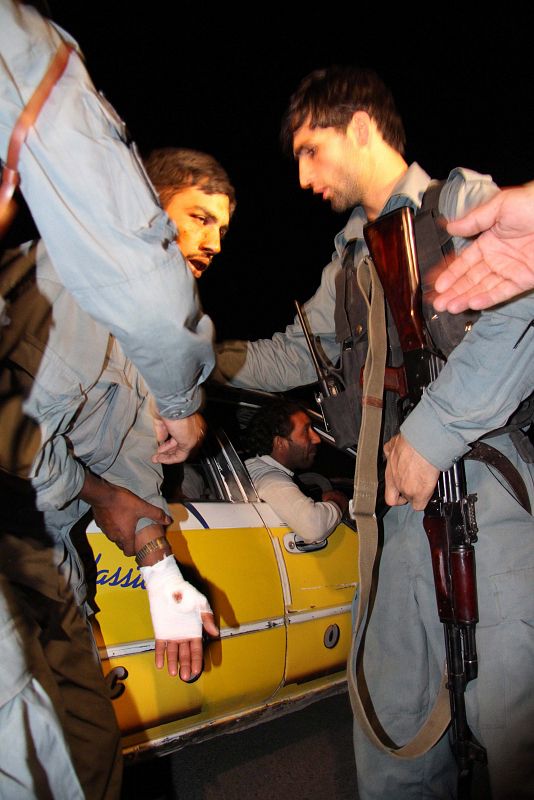 Policías afganos ayudan a un hombre herido en el atentado talibán en el Hotel Intercontinental