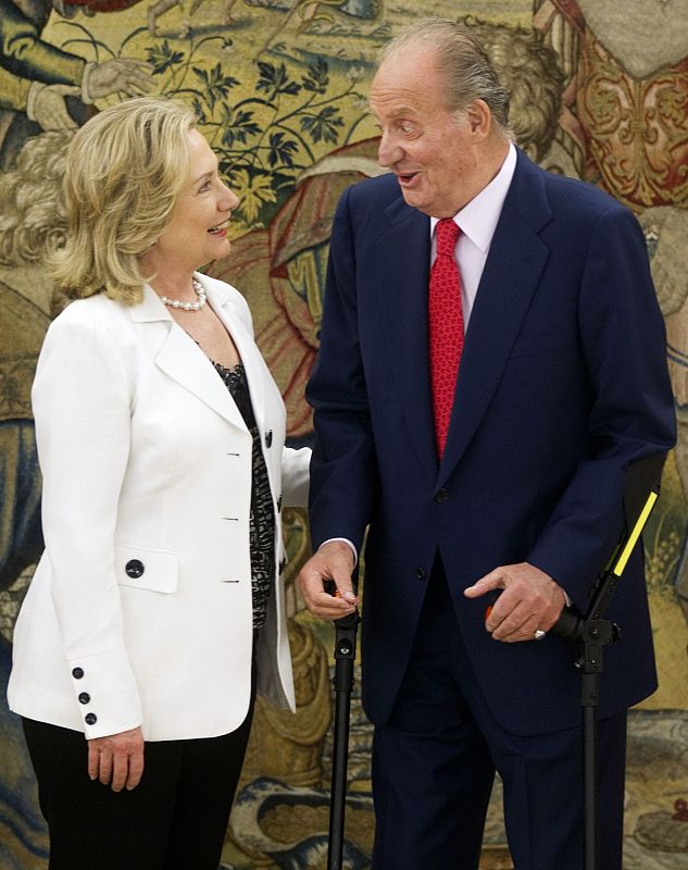 U.S. Secretary of State Clinton listens to Spanish King Juan Carlos before their meeting at Zarzuela Palace in Madrid