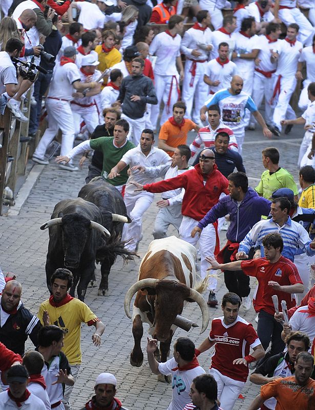 Corredores del encierro delante de los toros de Cebada Gago