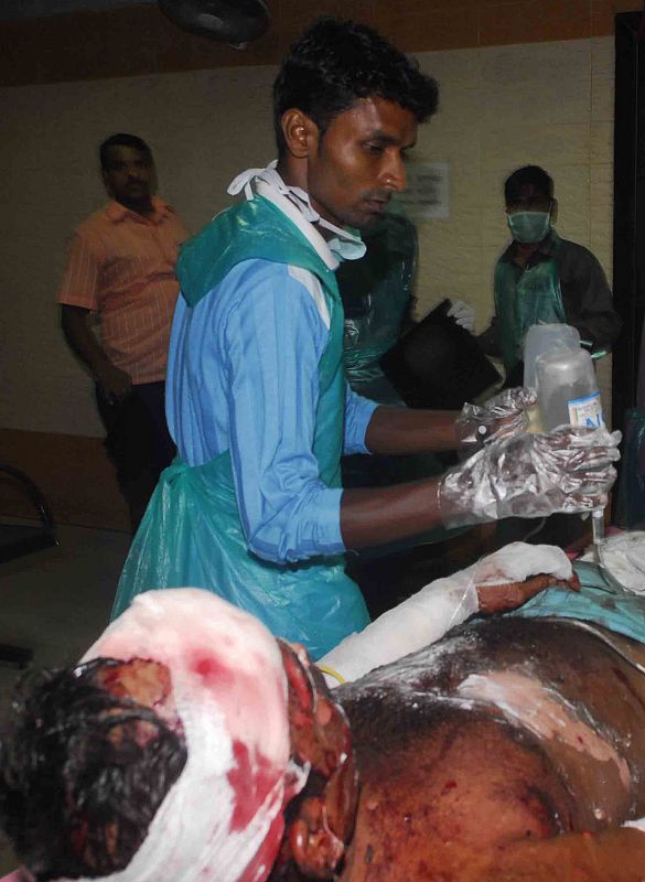 Un enfermero atiende a uno de los heridos tras las explosiones de hoy en la capital financiera de La India.