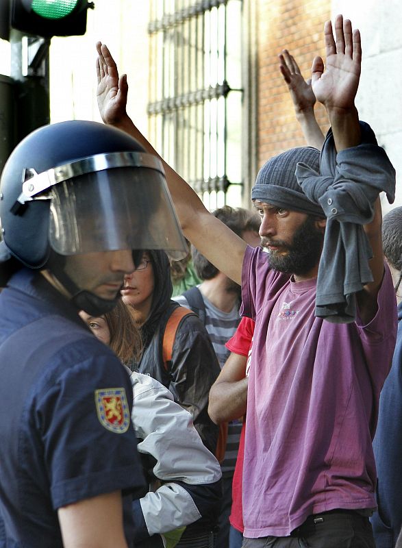 Un manifestante alza sus manos frente a la polícia