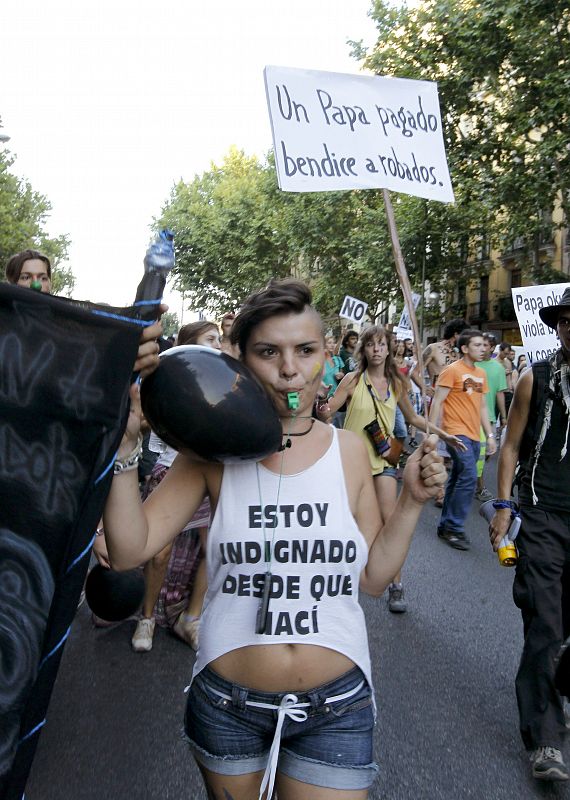 Una indignada muestra su eslogan en su camiseta durante la manifestación del movimiento 15M por la calle Atocha, en Madrid.