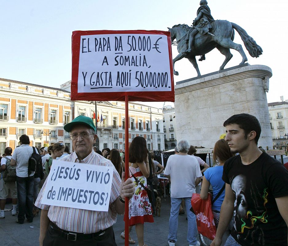 Un hombre muestra mensajes alusivos a la próxima visita del papa en la Puerta del Sol