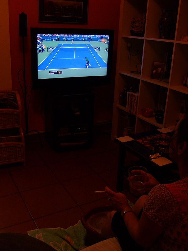 Mi madre viendo tenis con los pies en agua.