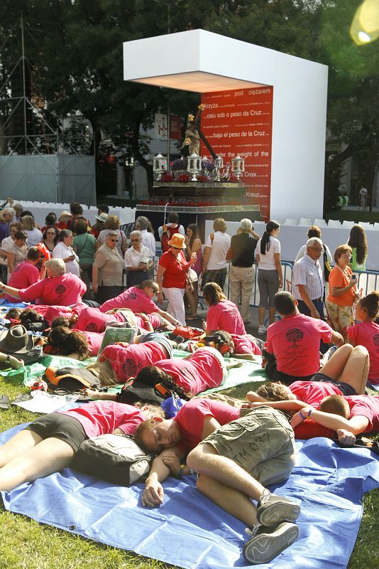 Un grupo de peregrinos descansa a la espera del "via crucis" que se celebrará hoy viernes por la tarde