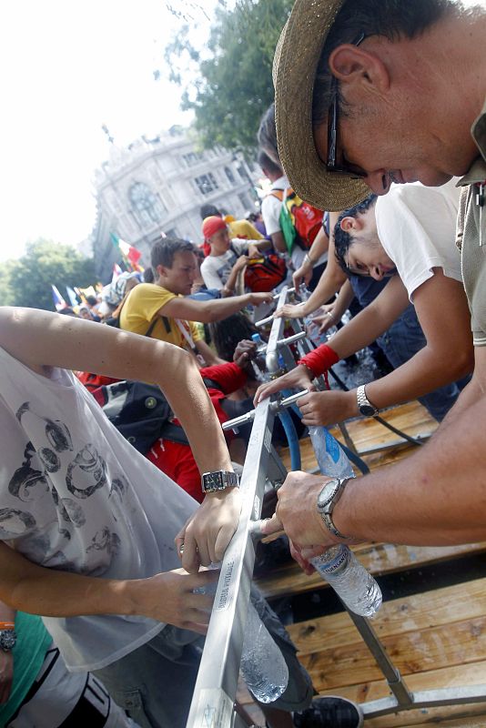 Varios jóvenes rellenan sus botellas de agua en las instalaciones dispuestas a tal efecto