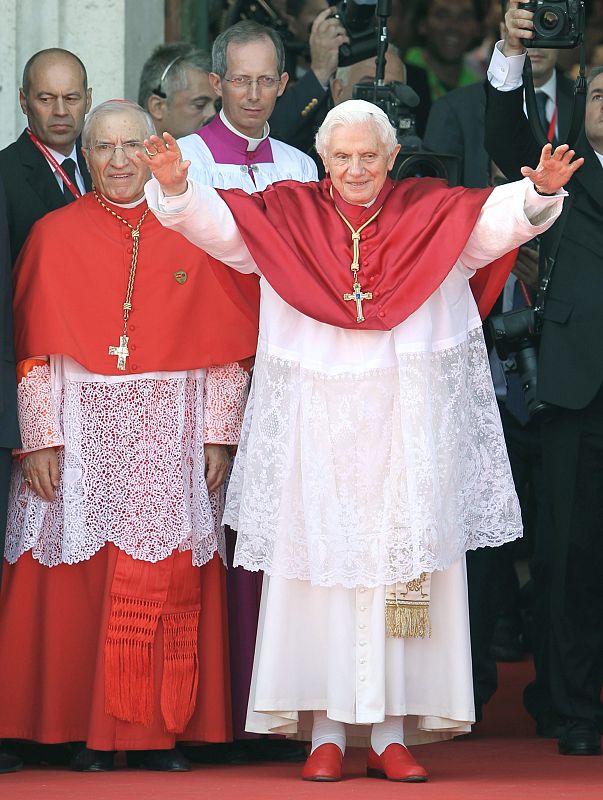 El papa Benedicto XVI junto al cardenal arzobispo de Madrid, Antonio María Rouco, (i) entre otros, saluda a su llegada a la catedral de La Almudena, para oficiar la misa para seminaristas