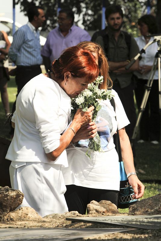 Dos familiares realizan la ofrenda floral a las víctimas