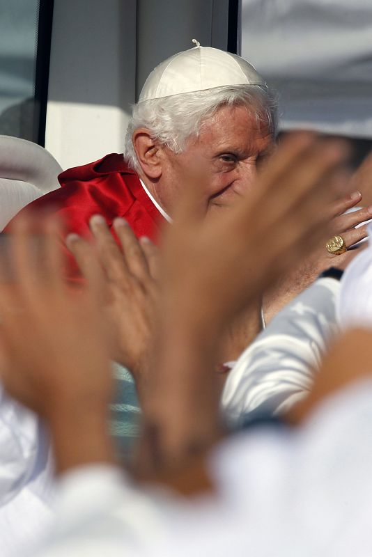 El papa Benedicto XVI saluda desde el papamóvil durante el recorrido que ha realizado por el aeródromo de Cuatro Vientos,