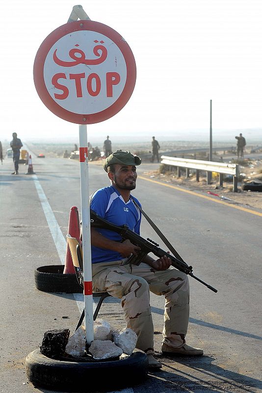 Un rebelde monta guardia en un punto de control en el puerto pedtrolero de Ras Lanuf (Libia)