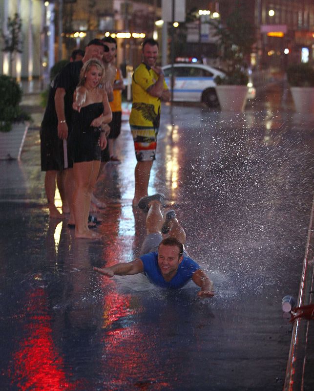 Un jóven se tira al suelo bajo la lluvia de Nueva York.