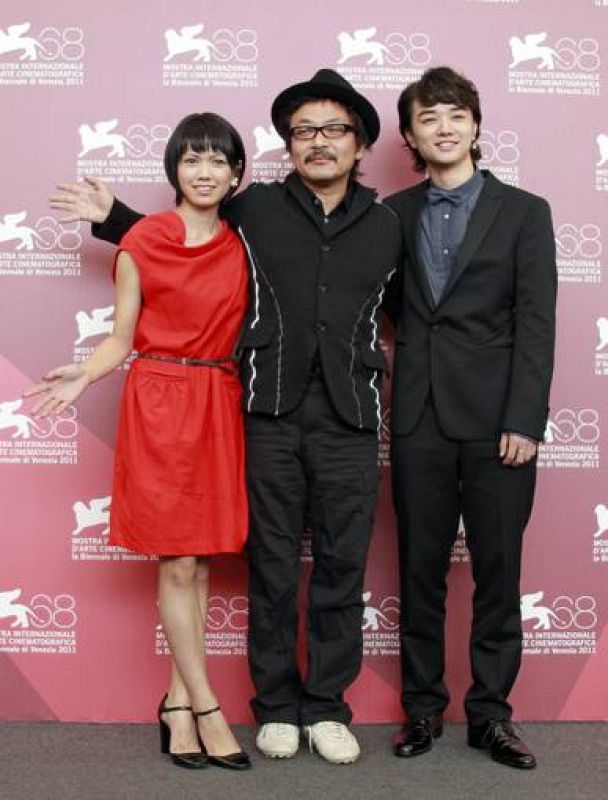 Director  Sono gestures as he poses with cast members Sometani and Nikaidou during a photocall for their film Himizu at the 68th Venice Film Festival