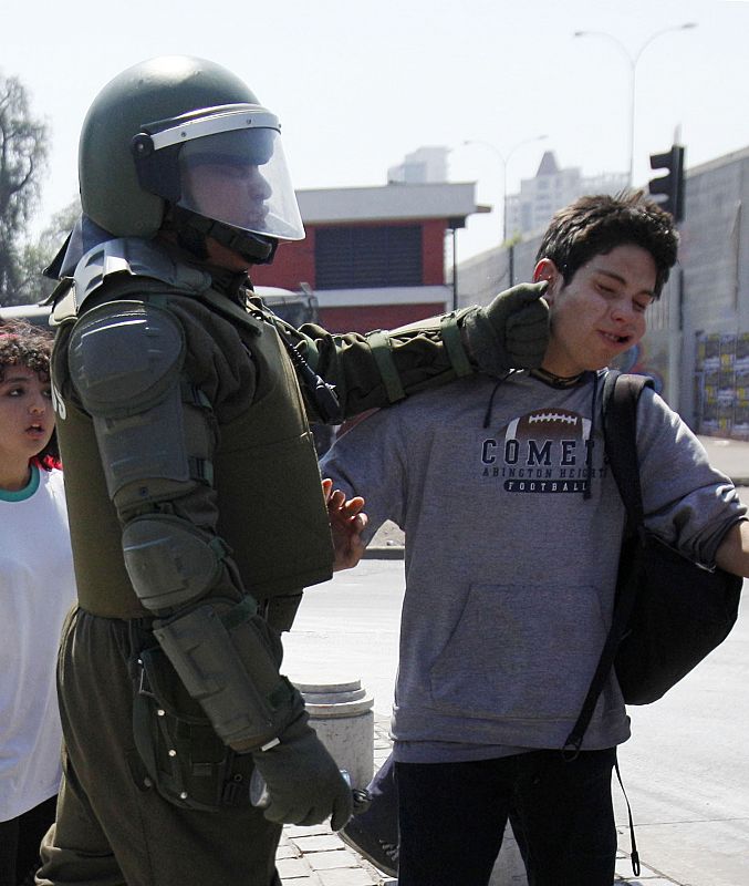 Un policía antimotines golpea a un estudiantes durante las manifestaciones