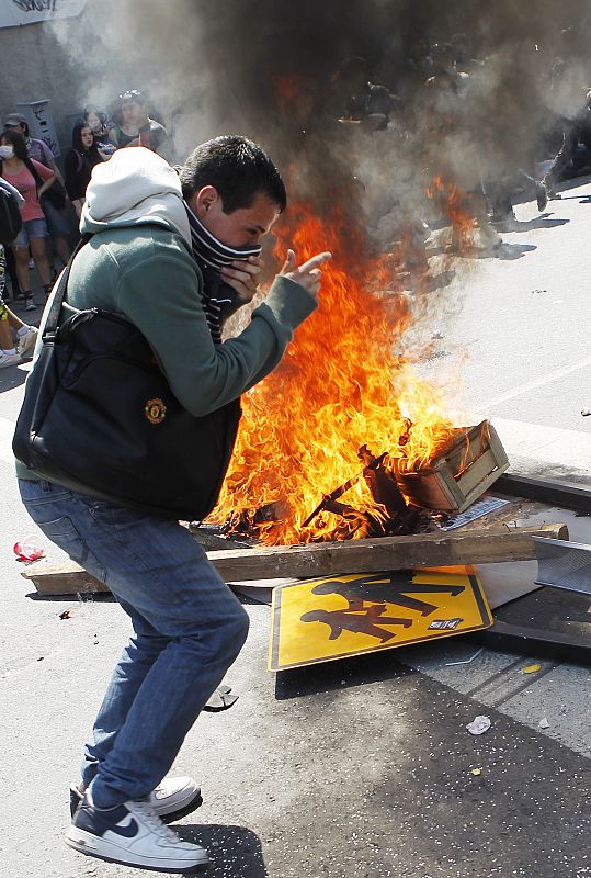 Un manifestantes que baila al rededor de una barricada en las protestas por un edacación gratuita