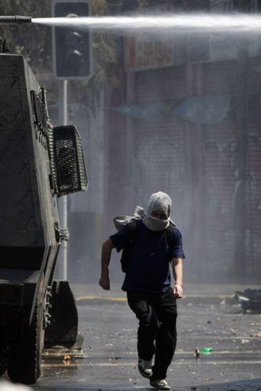 Los manifestantes junto los tanques de la policía que controla las protestas