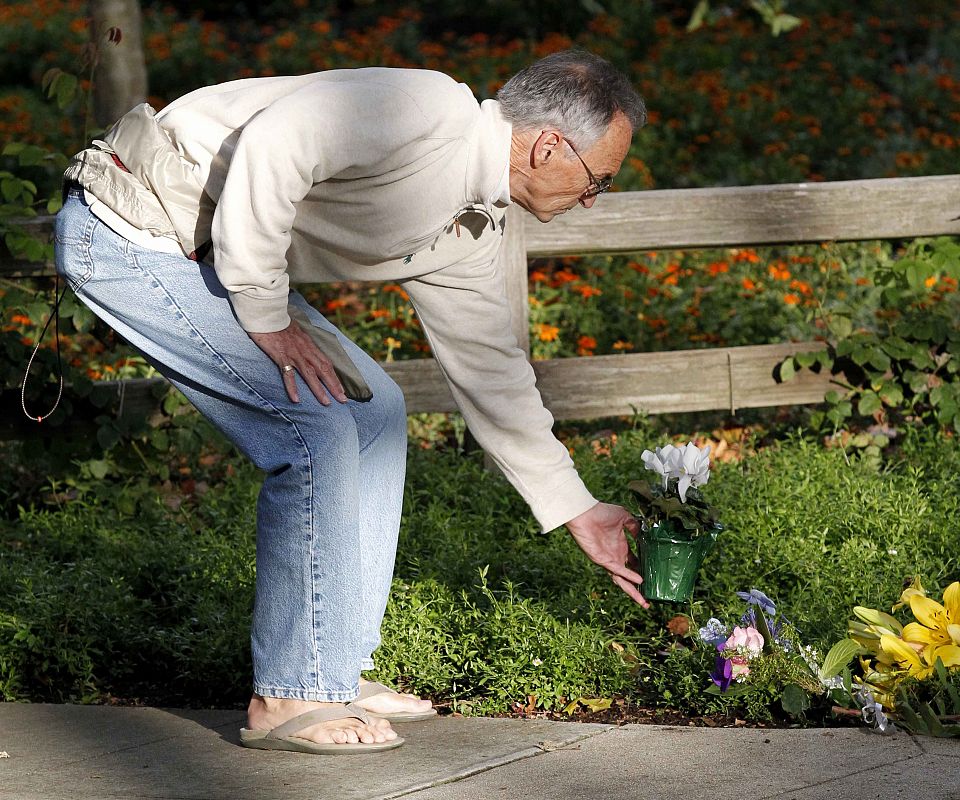 Un hombre coloca flores junto a la casa de Steve Jobs en Palo Alto (California)