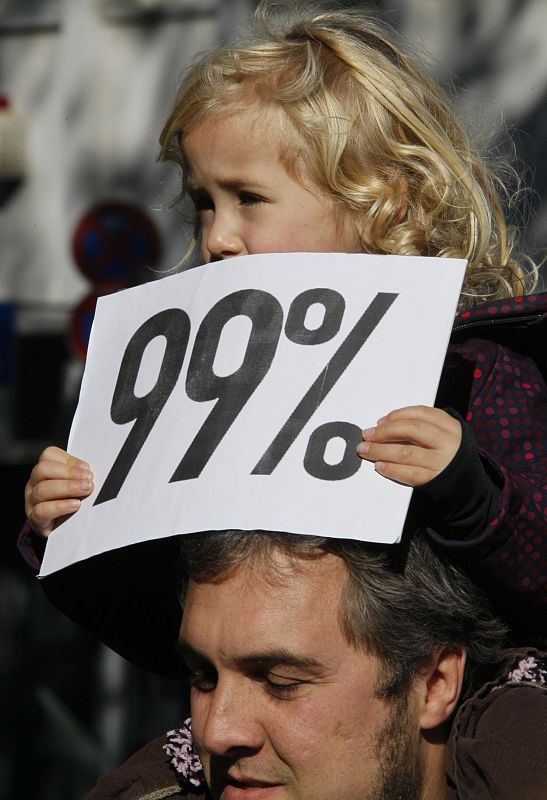 A girl holds a '99 percent' placard during a demonstration of several hundred people against banking and finance in Cologne