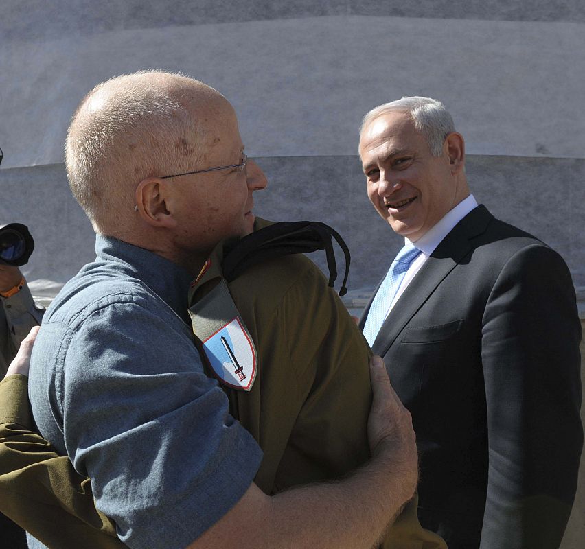 El soldado Gilad Shalit abraza a su padre en la base militar de Tel Nof, en Israel, ante la mirada del primer ministro israelí, Benjamin Netanhayu