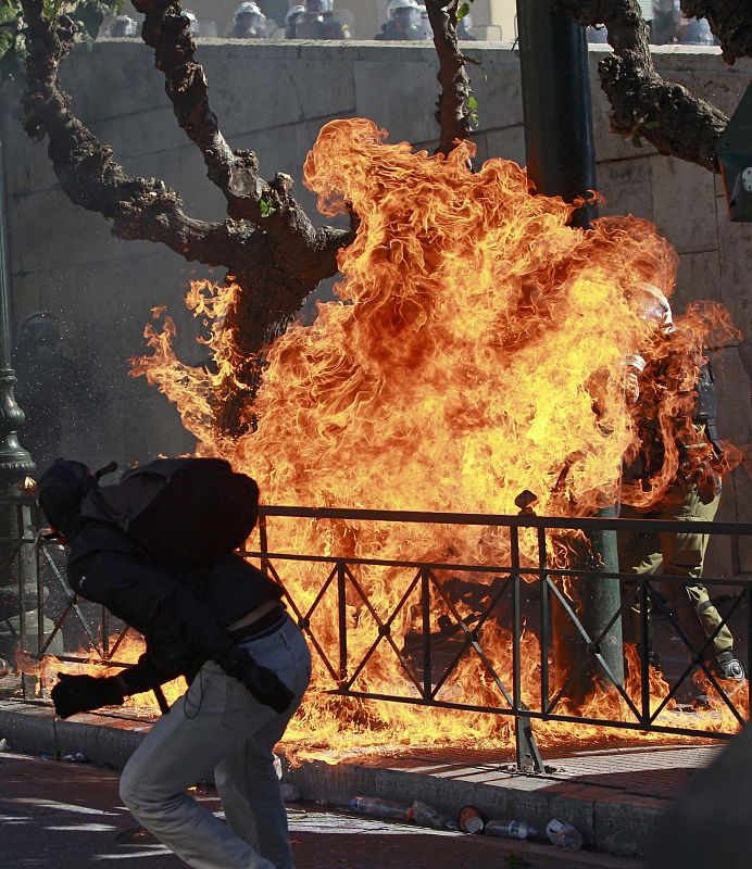 Un joven tira una bomba incendiaria contra el fue que se ha generado en los enfrentamientos