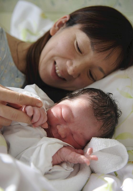 El pequeño Shota, recién nacido este lunes en Japón, sujeta el dedo de su madre