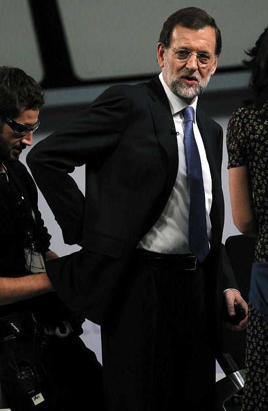 Un técnico coloca un micrófono a Rajoy antes del cara a cara con Rubalcaba