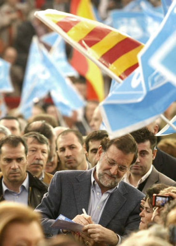 El presidente del PP, Mariano Rajoy (c), firma un autógrafo a su llegada hoy a la plaza de toros de Zaragoza 