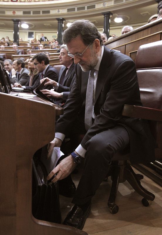 El líder del PP saca de su cartera el discurso que pronucia en la sesión de su investidura como presidente del Gobierno, en la que expone los detalles de la acción que pretende llevar a cabo al frente del Ejecutivo.