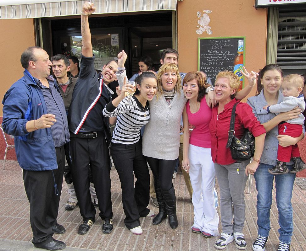 Algunos clientes del bar "Carlitos" de Huesca capital, donde se han repartido décimos del número 58.268, el Gordo de Navidad, celebran su suerte.